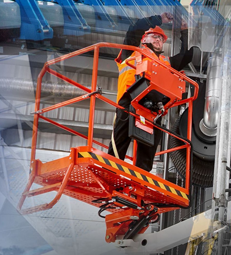 Operador con casco en la cesta de una plataforma elevadora